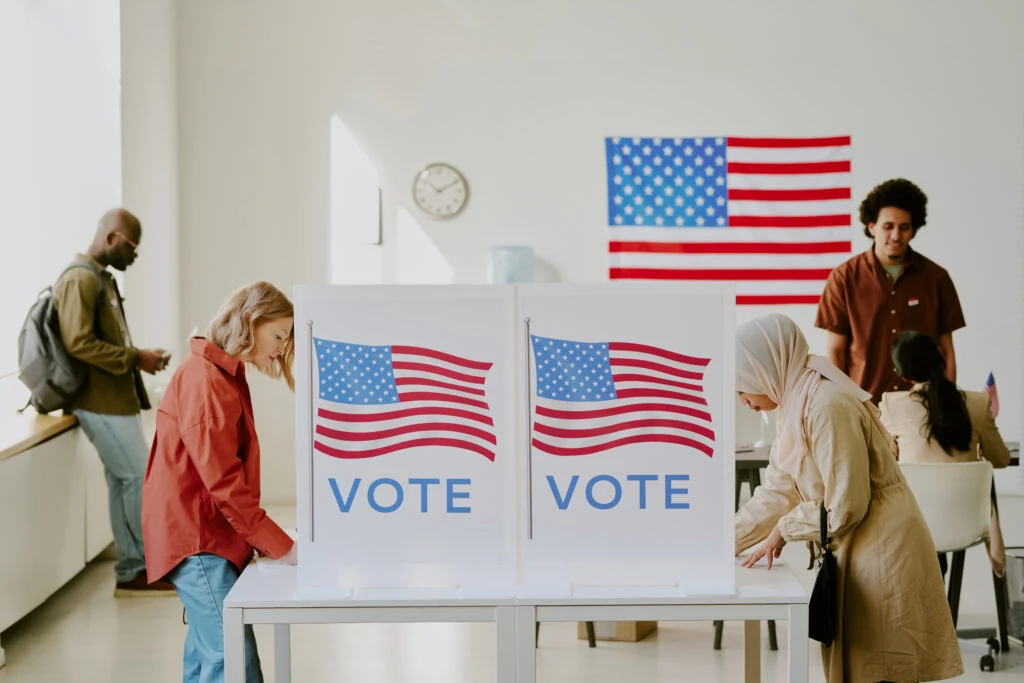 Voters casting their ballots at flag-draped voting booths