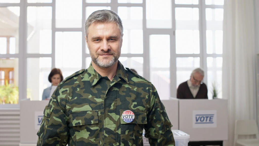 A veteran wearing a VOTE sticker at a polling station